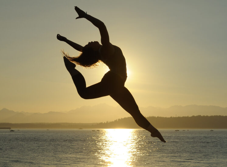 One-click: Gymnast catching the light over Puget Sound with the Olympic Mountains and golden water for a backdrop. Jerry and Lois Photography