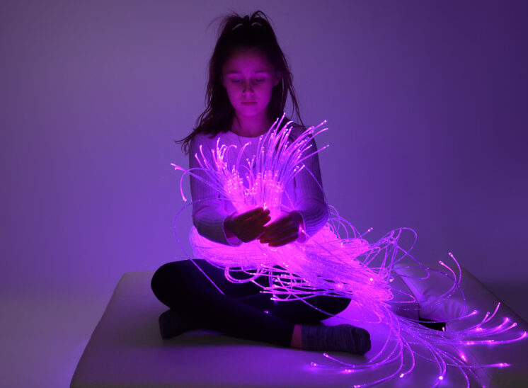 Playlearn product, young girl intrigued by glowing fiber optic product