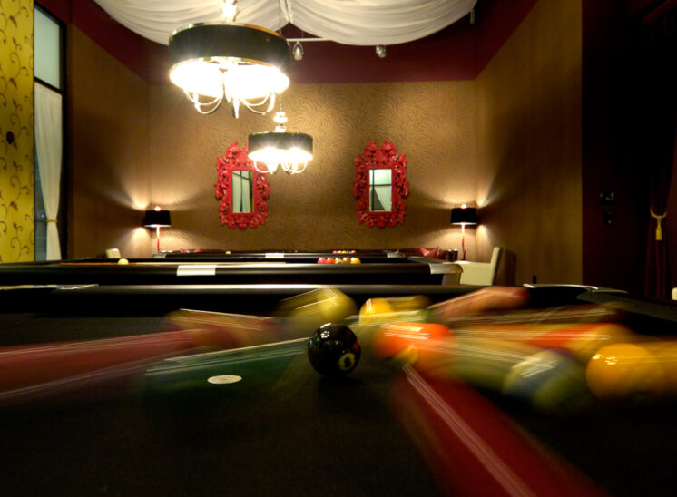 A perfectly moody setting for a motion-blurred break on a pool table, the 8 ball frozen in place. Camera-wise, literally a lucky break. © Jerry and Lois Photography