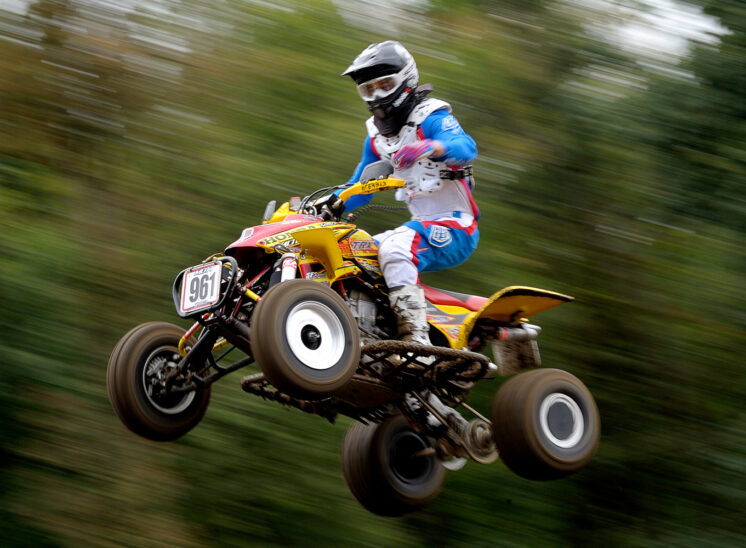 Part of a series for a Quad Motocross National Champion, demonstrating his amazing (and fearless) ability to catch air at 60+ mph. In sharp focus against a motion-blurred background. © Jerry and Lois Photography, all rights reserved